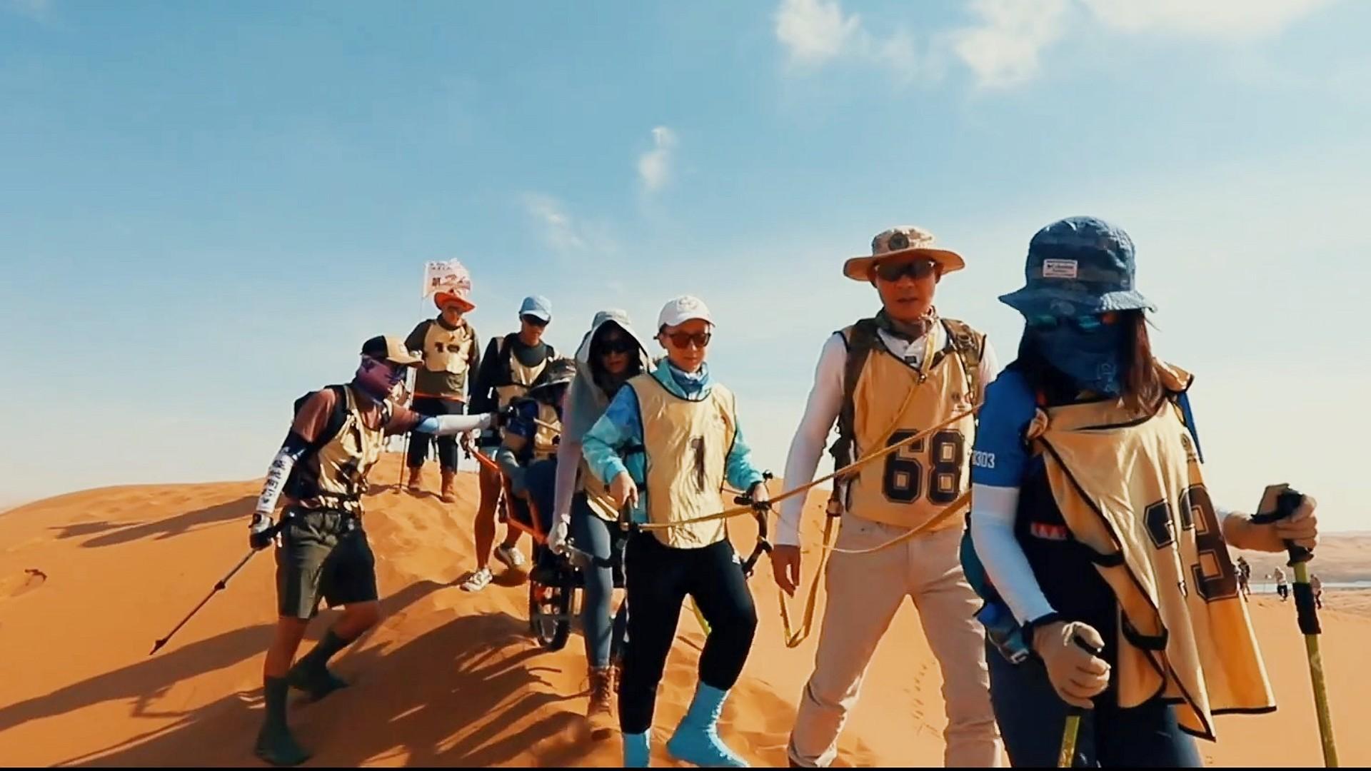 黃智賢與身後的國際獅子總會中國港澳303區總監沈顏,小心翼翼在沙漠行走。