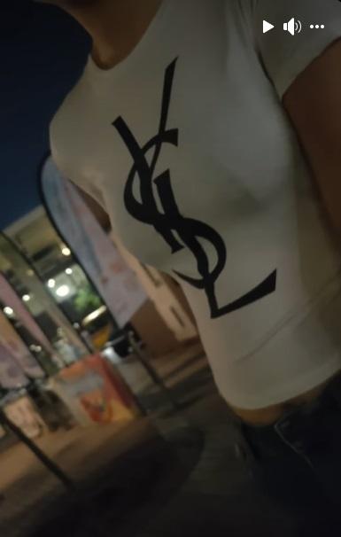 一名穿著印有「YSL(Saint Laurent)」字樣白色衣服的女子向拍片者借錢。(網片截圖)