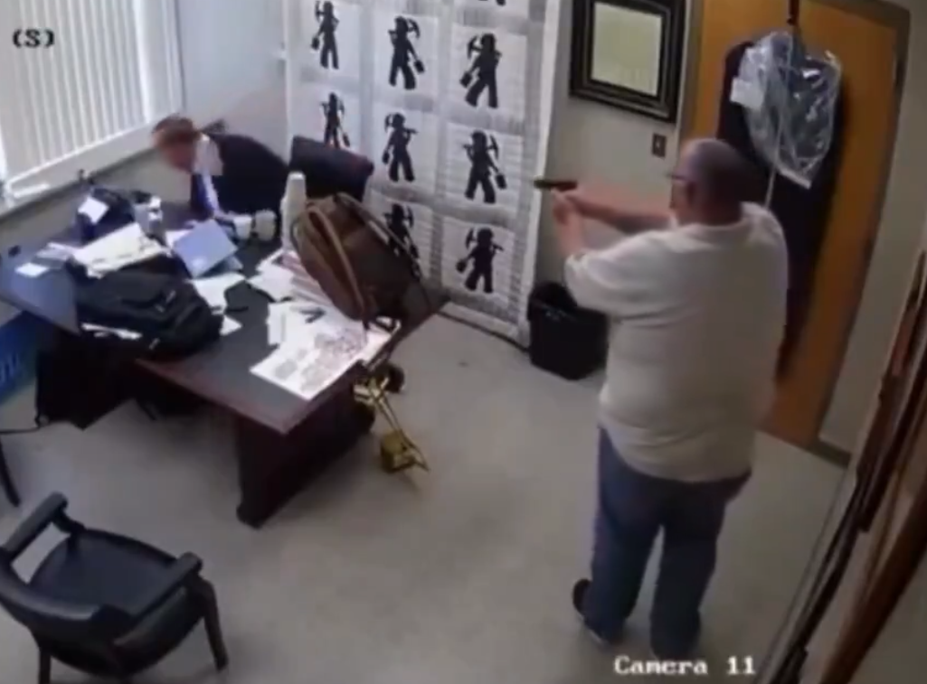 梅連斯(Kevin Mullins)嘗試以辦公室的桌子擋住。