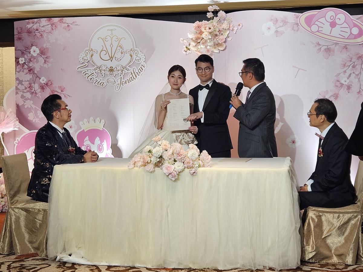 一對新人在雙方父親見證下簽婚書。