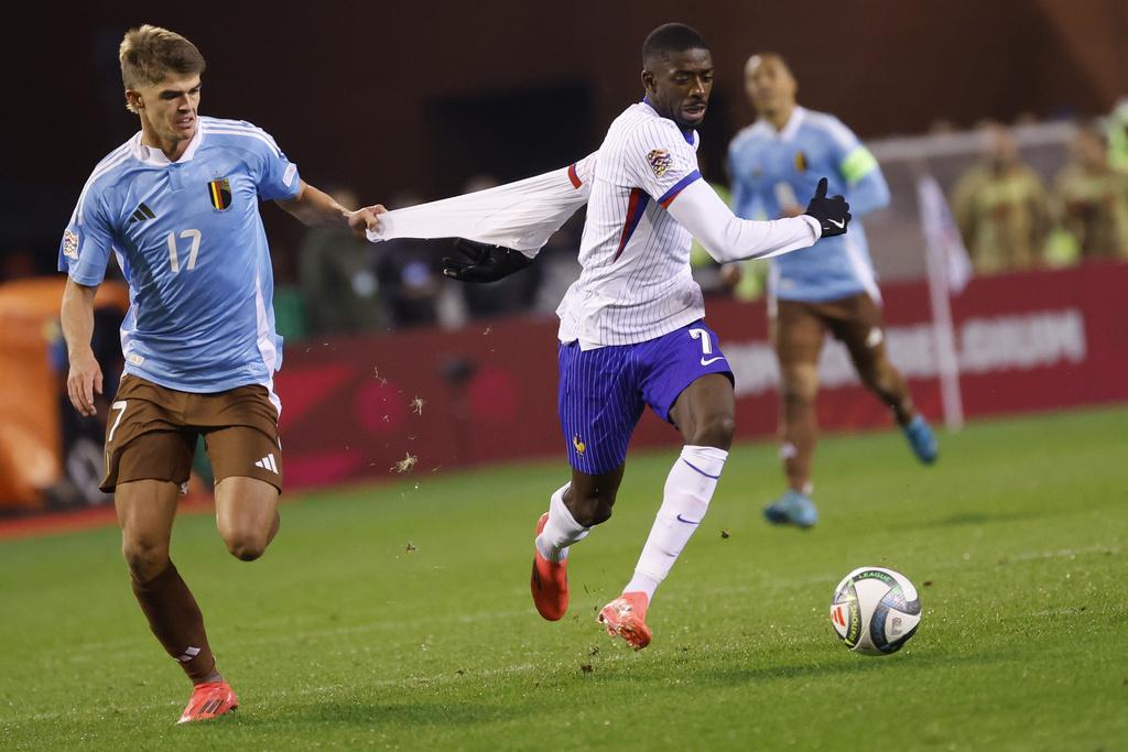 歐國聯|法國奧士文尼迪比利(Ousmane Dembele)被基迪拿尼(Charles De Ketelaere)拉衫。(美聯社)