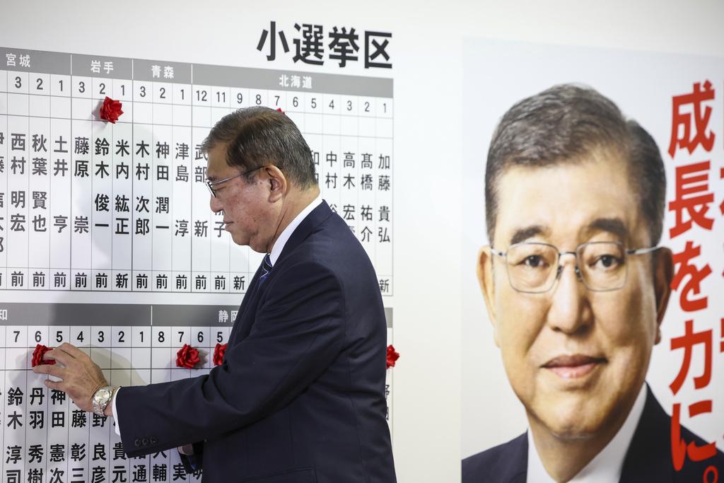 石破茂周日在自民黨總部等候點票結果,期間為勝出的候選人貼上標記。(資料圖片)