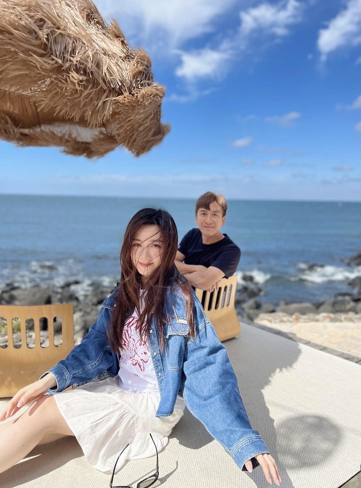 二人在陽光與海灘下合照,湯洛雯坐在前邊,而在後的馬國明猶如Key上去一樣。