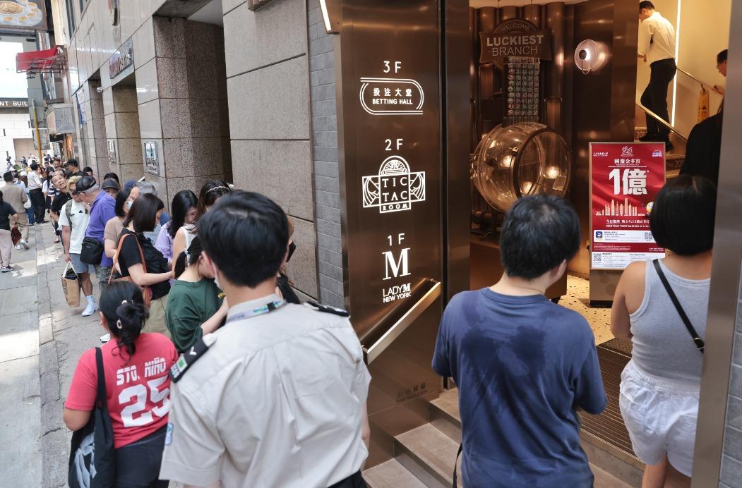 10月8日,香港中環賽馬會投注站前來投注六合彩國慶金多寶的市民大排長龍。(中通社)