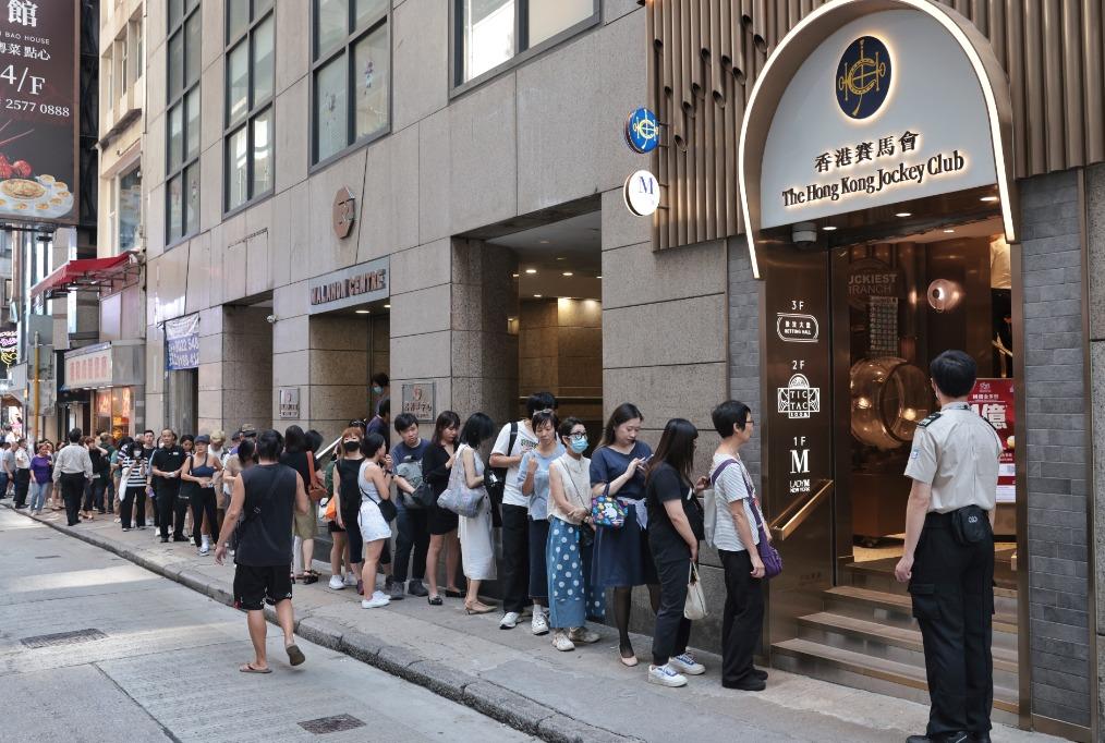 10月8日,香港中環賽馬會投注站前來投注六合彩國慶金多寶的市民大排長龍。(中通社)