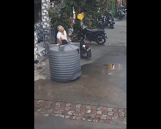 女子從水塔頂部伸頭出來,男途人鬆一口氣,望向上方。(互聯網)