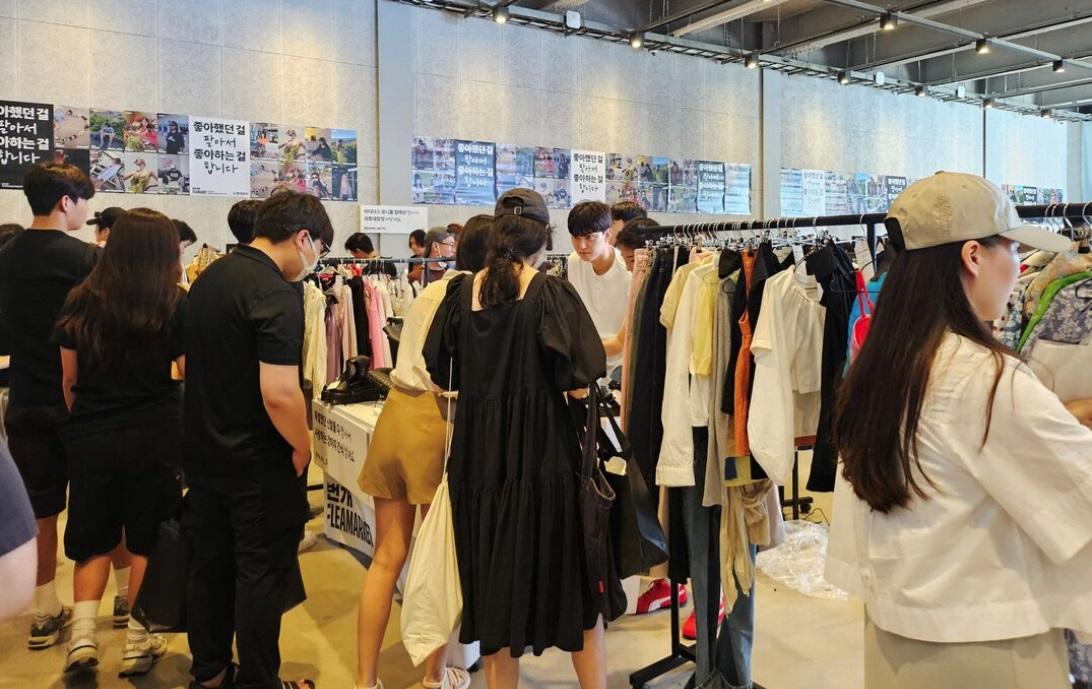 南韓社會普遍注重外貌。圖為年輕男子在二手市場選購衣物。(資料圖片)