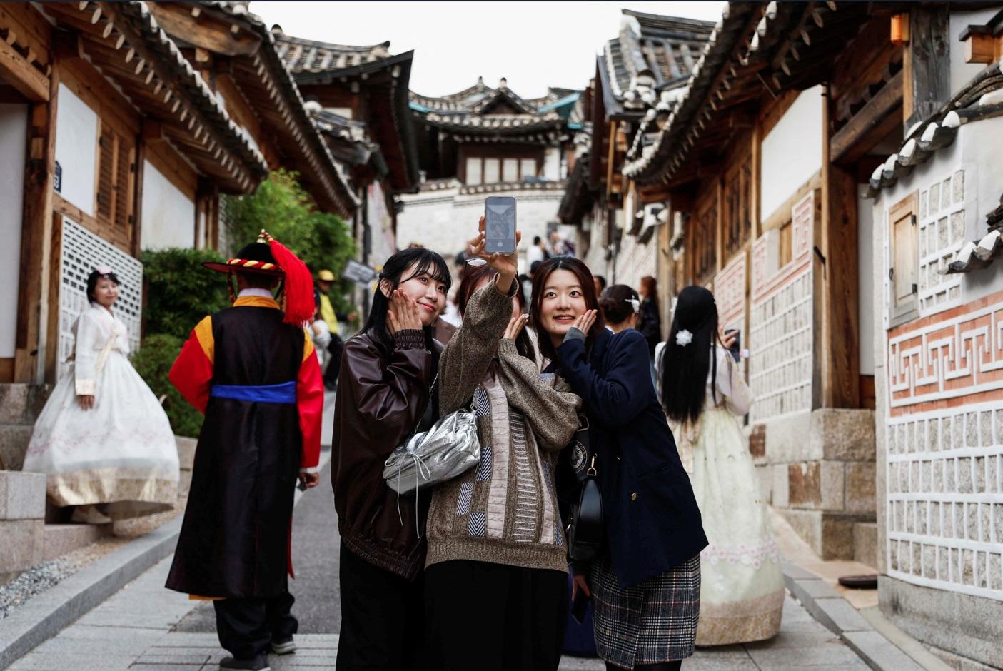 遊客在街上自拍。(路透社)