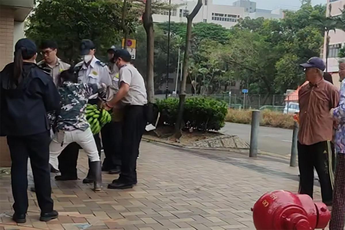 數名食環署職員包圍一名女小販及其貨物。(網民Desmond Wang@FB群組「皇后山乜都友」)