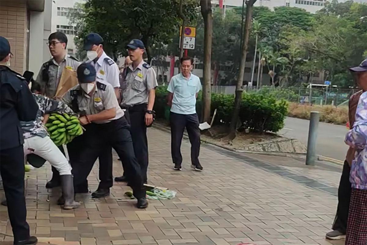 數名食環署職員包圍一名女小販及其貨物。(網民Desmond Wang@FB群組「皇后山乜都友」)