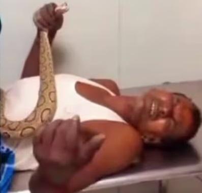 男子被送去治療時,仍捉住蛇口。(互聯網)