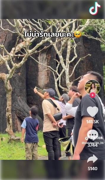 鴨舌帽女子用彈弓朝上方射擊,其他遊客注視,沒有阻止。(互聯網)