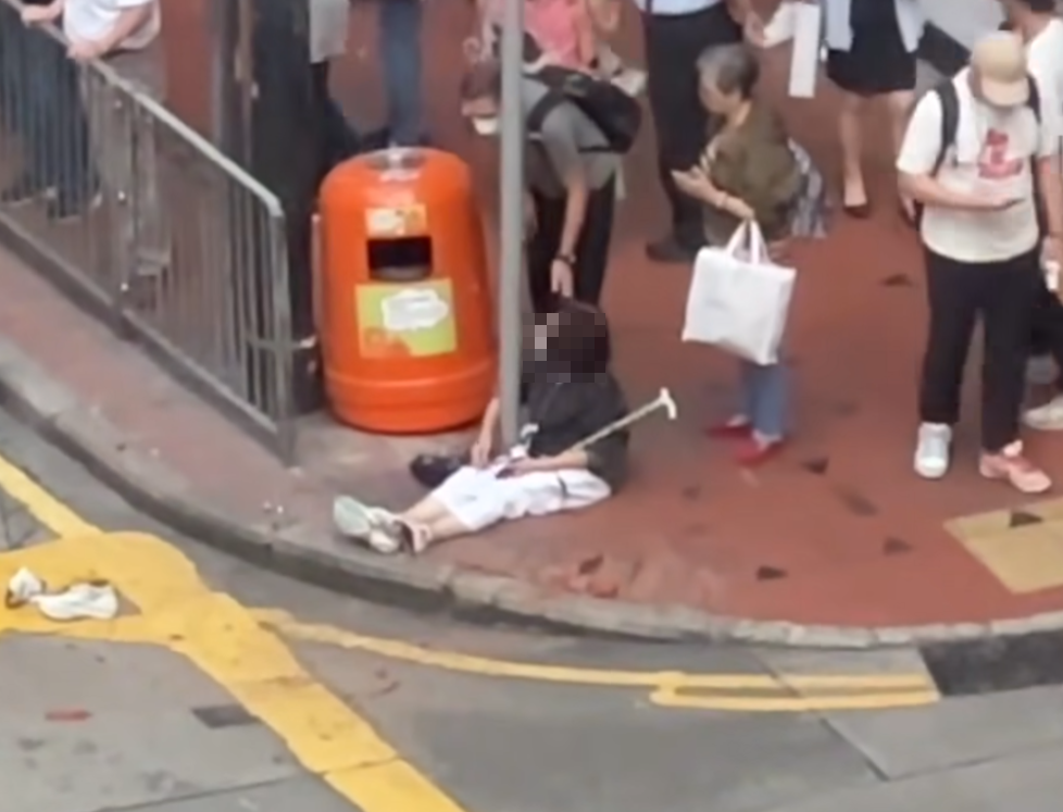 意外後兩名傷者分別倒臥在車頭前方及坐在行人路,均有反應,多名駕駛人士及路人上前慰問傷者,七人車司機亦有下車了解。(香港突發事故報料區及討論區fb)