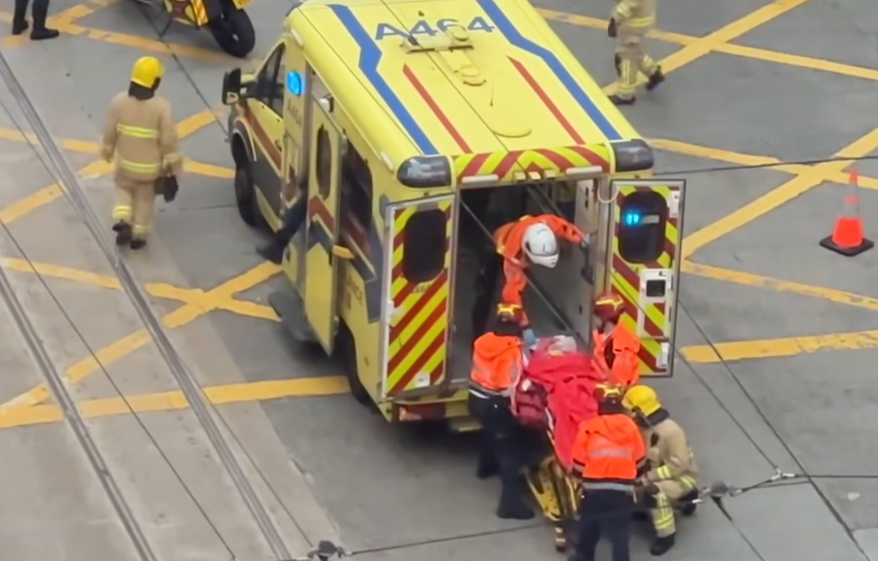 救護人員先後將倒臥車頭前方及坐在路邊的兩名女傷者移到擔架床上,由救護車將兩人送院。(香港突發事故報料區及討論區fb)