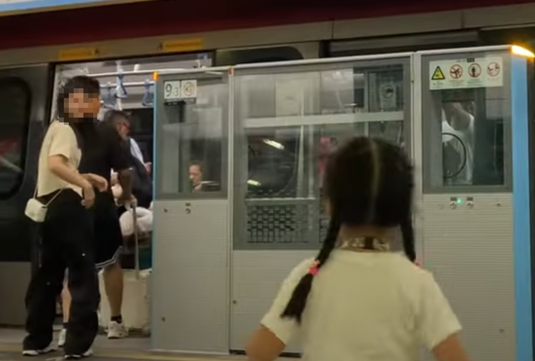 帶着一對仔女的母親於港鐵落馬洲站時情急衝門,惟她未有拖實二人,與緊跟其後的兒子及時進入車廂(影片截圖)