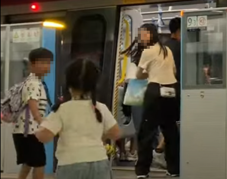 帶着一對仔女的母親於港鐵落馬洲站時情急衝門,惟她未有拖實二人,與緊跟其後的兒子及時進入車廂(影片截圖)
