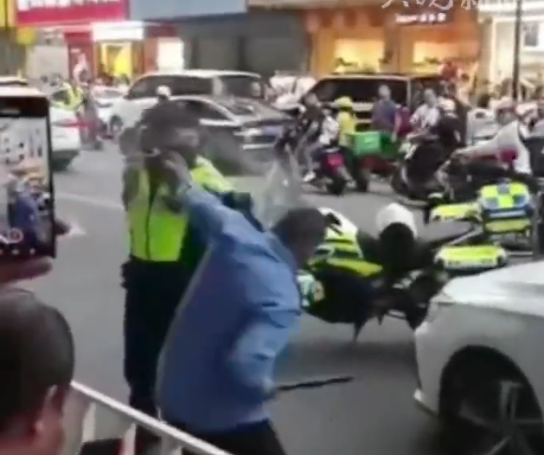 「輔警」手持短棍揮舞阻止交警靠近,又從車上取水狂喝。當男子走上私家車後,交警趁機奪走其短棍,之後男子企圖駕車逃離現場,惟被胡椒噴霧制服。(影片截圖)