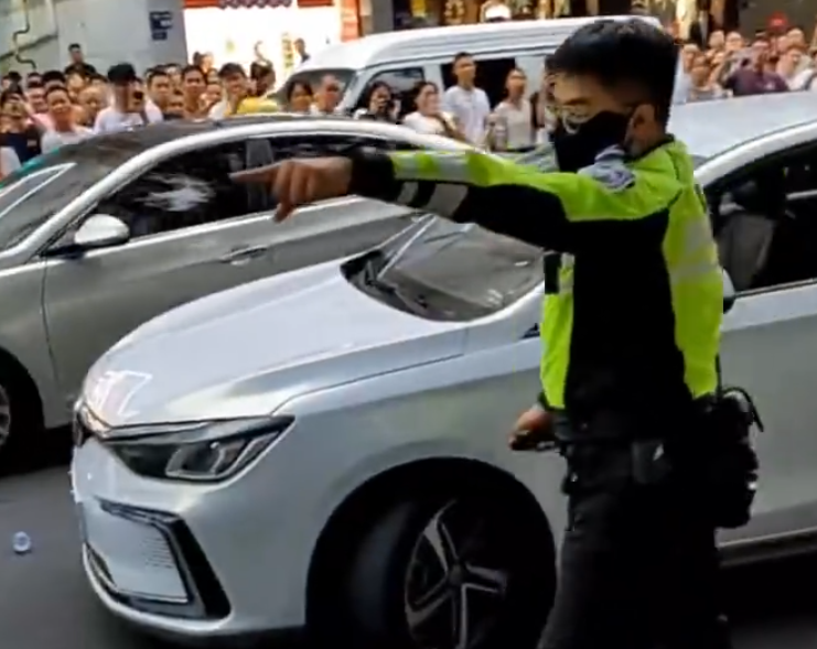 「輔警」手持短棍揮舞阻止交警靠近,又從車上取水狂喝。當男子走上私家車後,交警趁機奪走其短棍,之後男子企圖駕車逃離現場,惟被胡椒噴霧制服。(影片截圖)