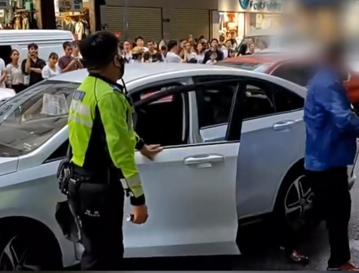 「輔警」手持短棍揮舞阻止交警靠近,又從車上取水狂喝。當男子走上私家車後,交警趁機奪走其短棍,之後男子企圖駕車逃離現場,惟被胡椒噴霧制服。(影片截圖)