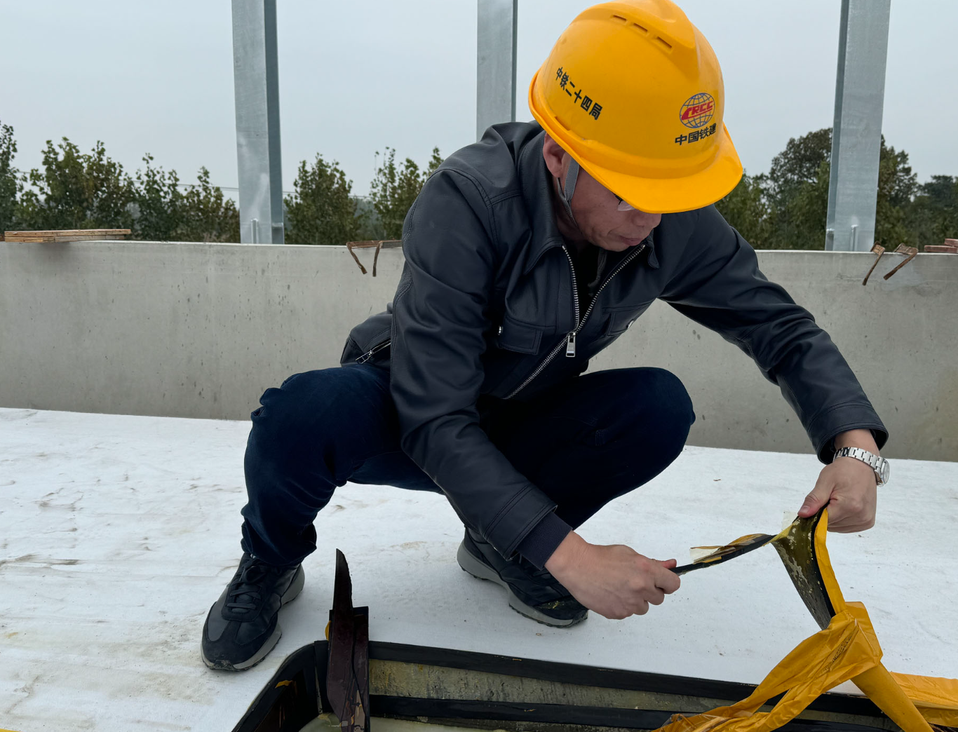 在施工現場,已鋪好的彈性墊層「一割就開,一扯就斷」。(經濟參考報)
