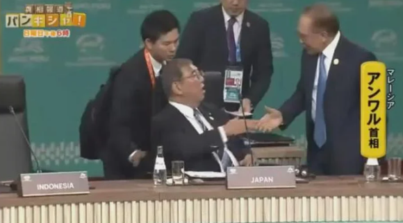 在APEC峰會舉行前,馬來西亞首相安華向石破茂打招呼,他須工作人員提醒才發覺。(互聯網)