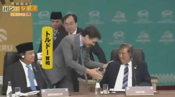 在APEC峰會舉行前,杜魯多主動向石破茂打招呼,而他只坐著回應。(互聯網)