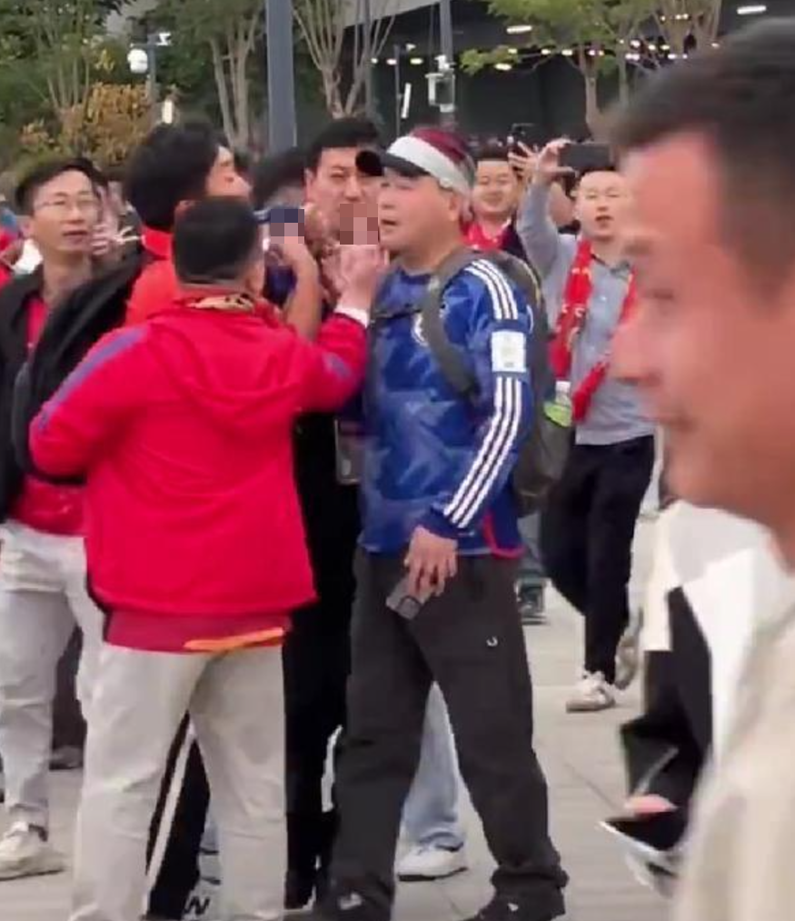 網傳影片顯示,昨日下午在廈門奧體中心白鷺體育場外,一名男子身穿日本隊的藍色球衣出現在驗票區,立刻遭到數十名中國球迷包圍辱罵,甚至稱其「漢奸」。(影片截圖)
