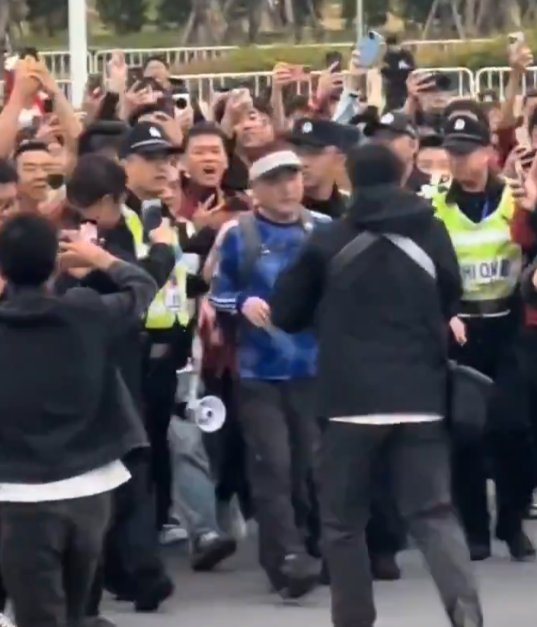 網傳影片顯示,昨日下午在廈門奧體中心白鷺體育場外,一名男子身穿日本隊的藍色球衣出現在驗票區,立刻遭到數十名中國球迷包圍辱罵,甚至稱其「漢奸」。(影片截圖)