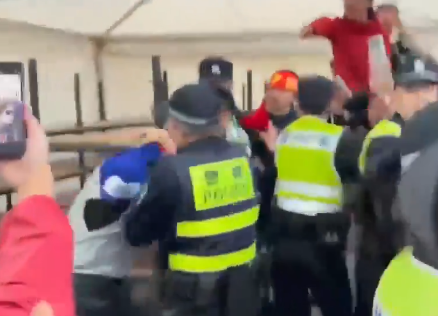 在場警員為平息眾怒,最後亦強行脫下該男子所穿球衣,並迅速把他帶走。(影片截圖)