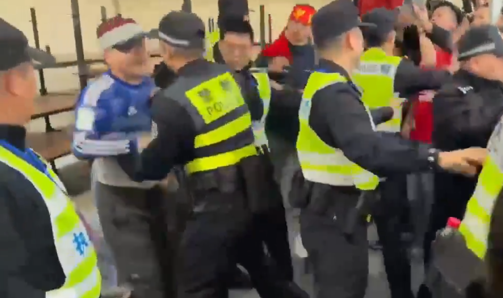 在場警員為平息眾怒,最後亦強行脫下該男子所穿球衣,並迅速把他帶走。(影片截圖)