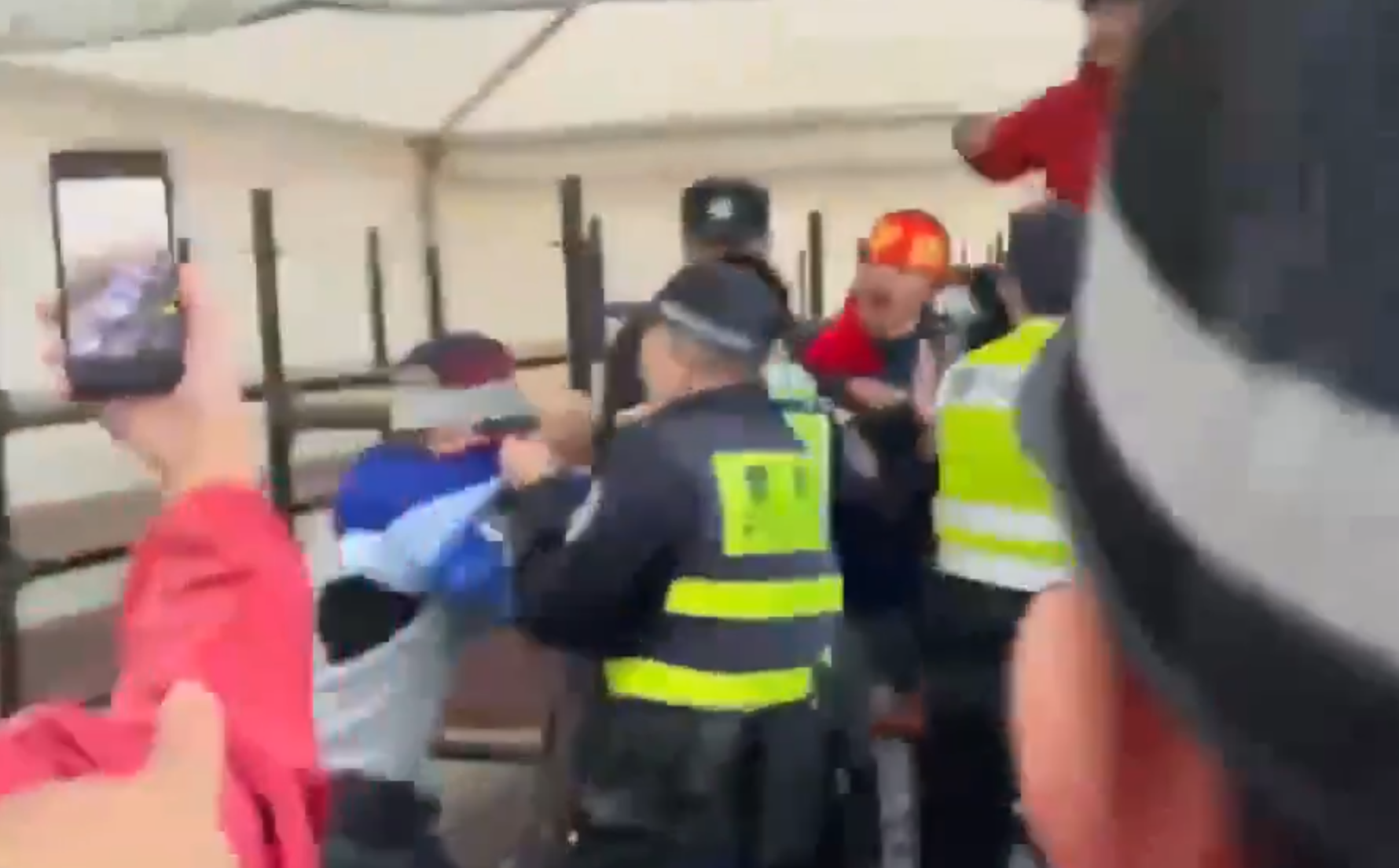 在場警員為平息眾怒,最後亦強行脫下該男子所穿球衣,並迅速把他帶走。(影片截圖)