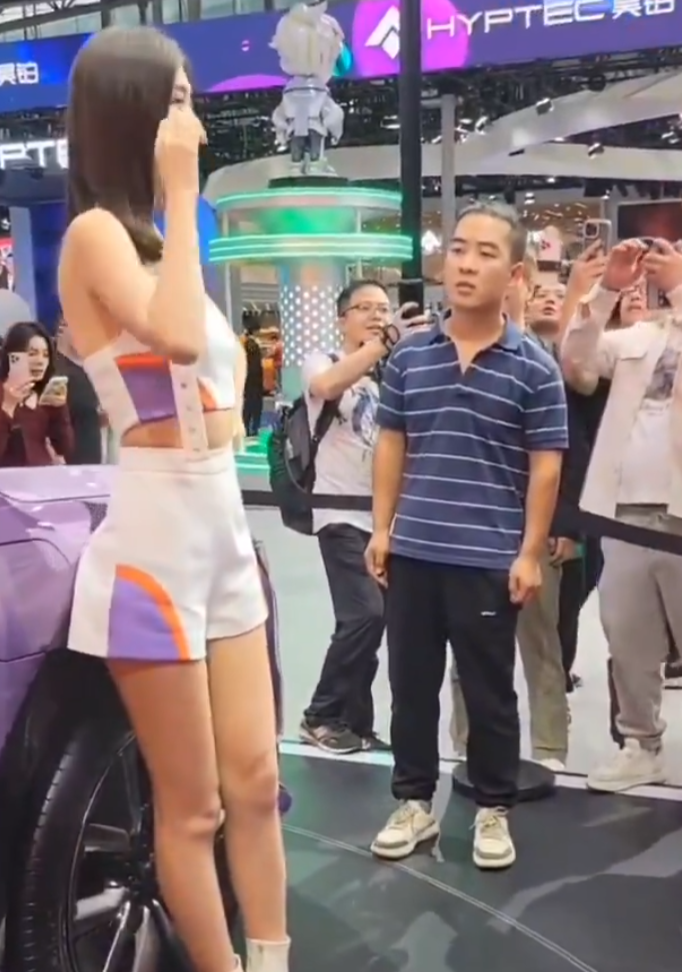 內地近日一名身著藍白條紋T恤的男子現身多地車展現場,並以專注眼神「沉浸式凝視」女模,結果被網民封為「條紋哥」成為紅人(影片截圖)