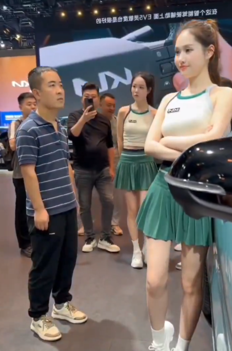 內地近日一名身著藍白條紋T恤的男子現身多地車展現場,並以專注眼神「沉浸式凝視」女模,結果被網民封為「條紋哥」成為紅人(影片截圖)
