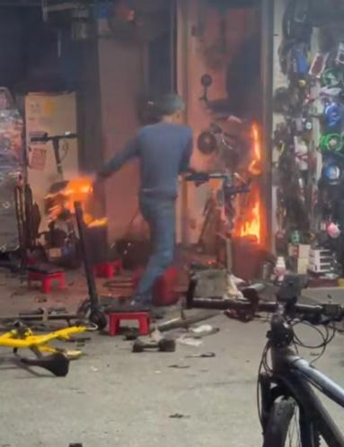 店主將燃燒的雜物拋到店前空地試圖救火。(車cam L(香港群組)@FB)