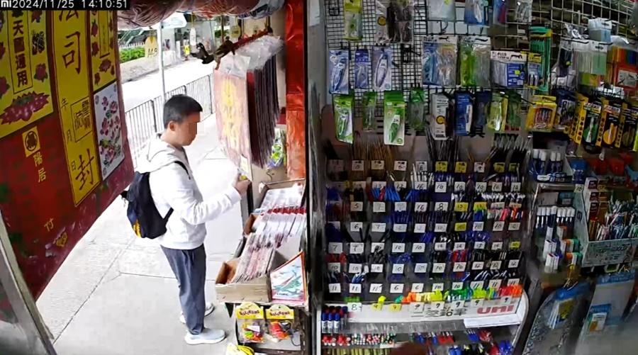 男子一手拿起兩隻陀螺細看,之後收在手裡。(筲箕灣西灣河關注組@FB)