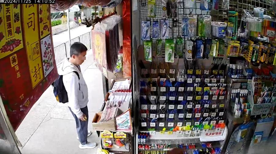 男子一手拿起兩隻陀螺細看,之後收在手裡。(筲箕灣西灣河關注組@FB)