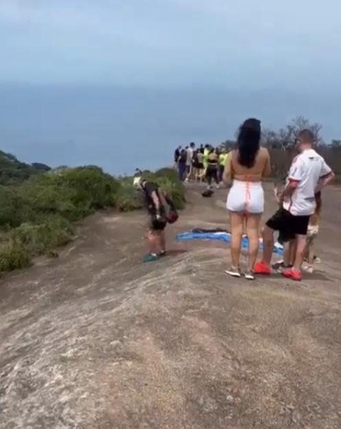 Jose戴著頭盔,揹著跳傘背囊,背囊拖著一幅平舖地上的降傘。(X)