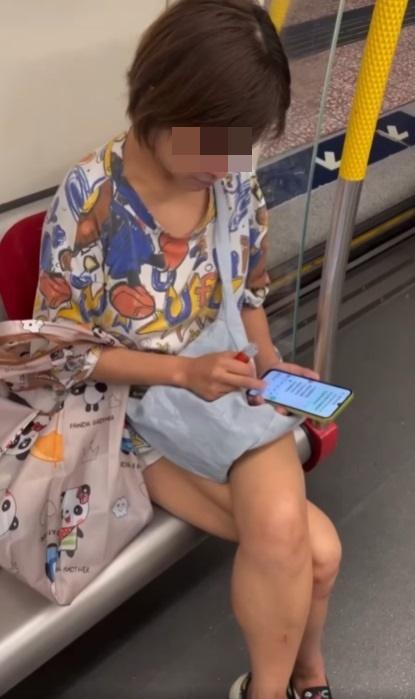 一名中年婦女坐在港鐵關愛座上,期間懷疑吸食電子煙,大模廝樣地吞雲吐霧。(網片截圖)