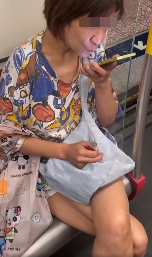 一名中年婦女坐在港鐵關愛座上,期間懷疑吸食電子煙,大模廝樣地吞雲吐霧。(網片截圖)