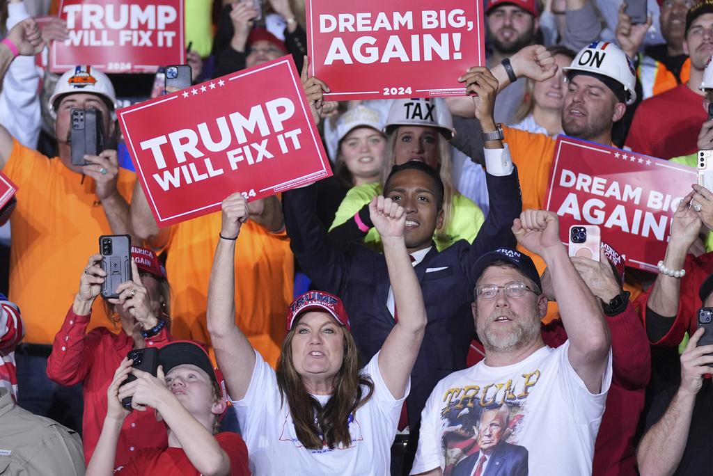 在密歇根州集會上,群眾高舉支持特朗普的標語。(美聯社)