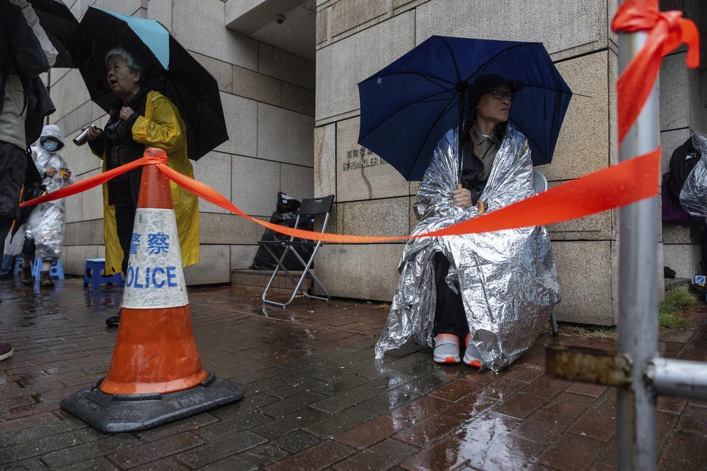 不少市民在法院外冒雨排隊輪候旁聽席位。(AP)