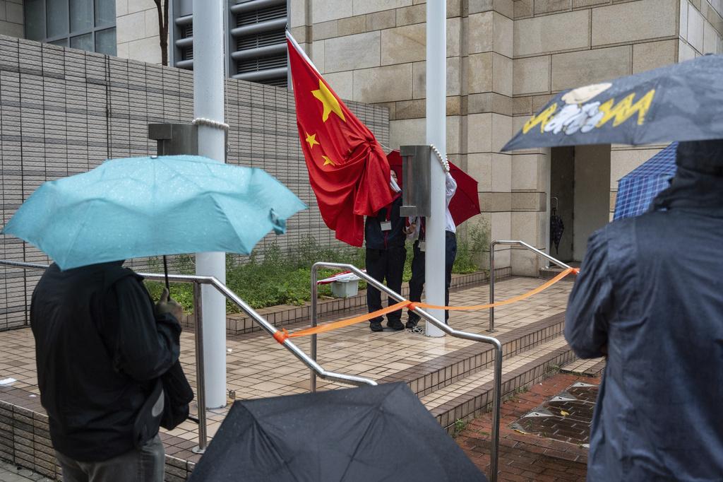工作人員在西九龍裁判法院外升起中國國旗,據報為即將舉行審理的黎智英案件準備。(AP)
