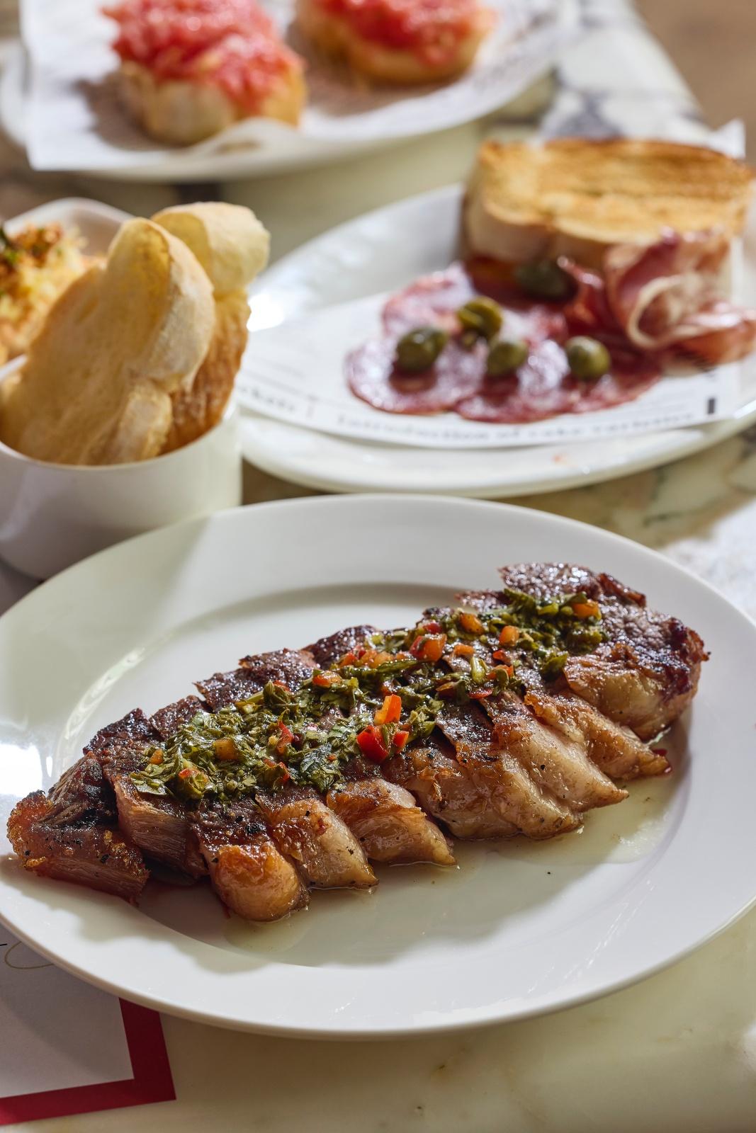 午巿套餐之炭烤肋眼牛扒配惹味青醬 用西班牙頂級烤爐高溫燒烤,外層焦脆內裡鎖著肉汁。