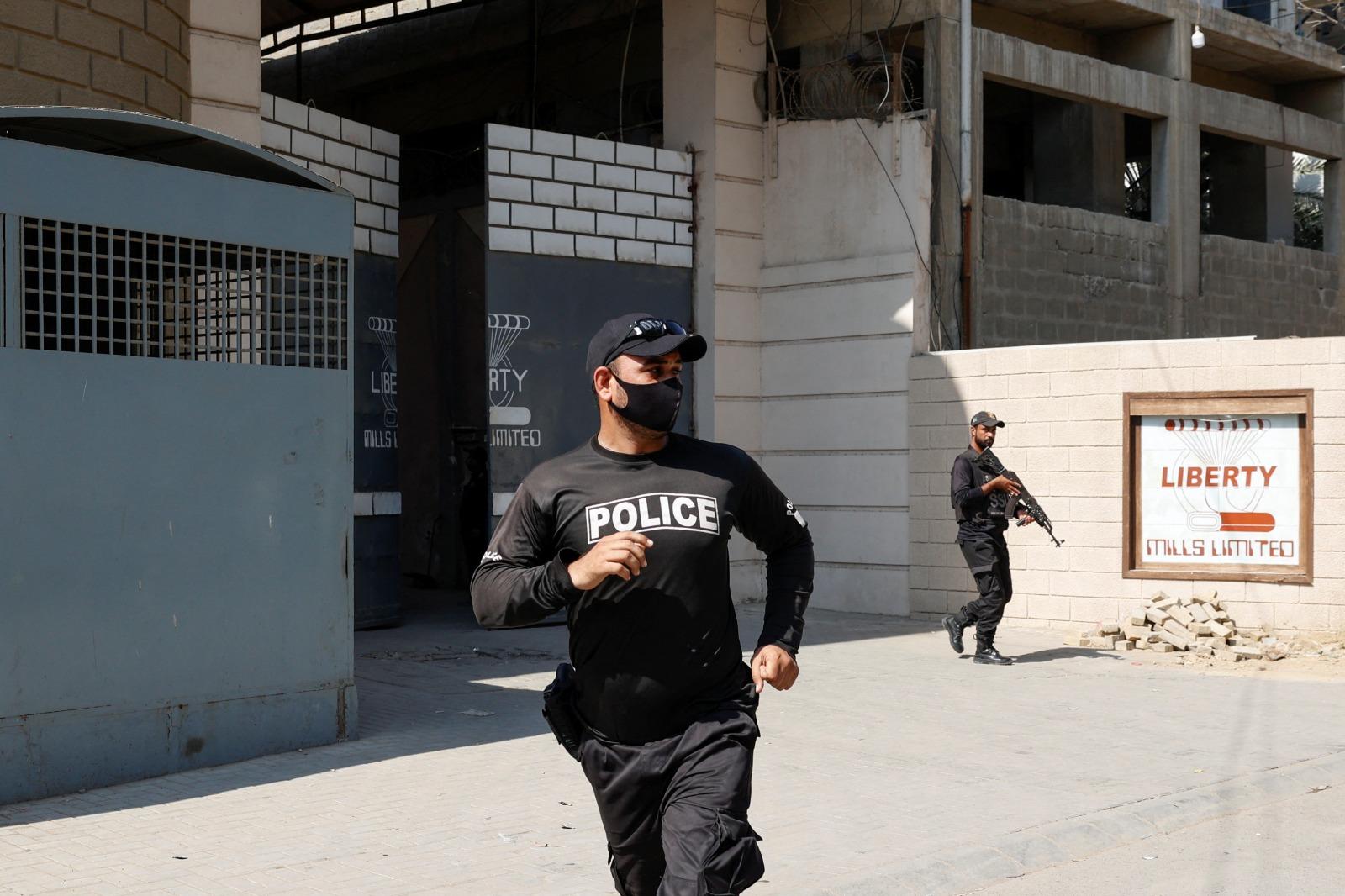 巴基斯坦卡拉奇紡織廠外兩名中國公民遭保安員槍擊受傷,事後大批警員到場,封鎖現場調查。(路透社)