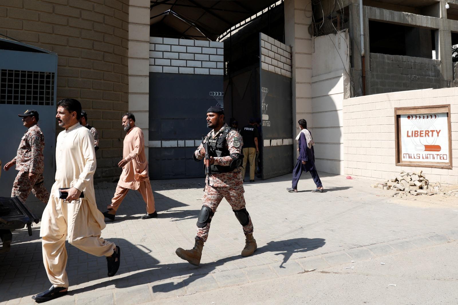 巴基斯坦卡拉奇紡織廠外兩名中國公民遭保安員槍擊受傷,事後大批警員到場,封鎖現場調查。(路透社)