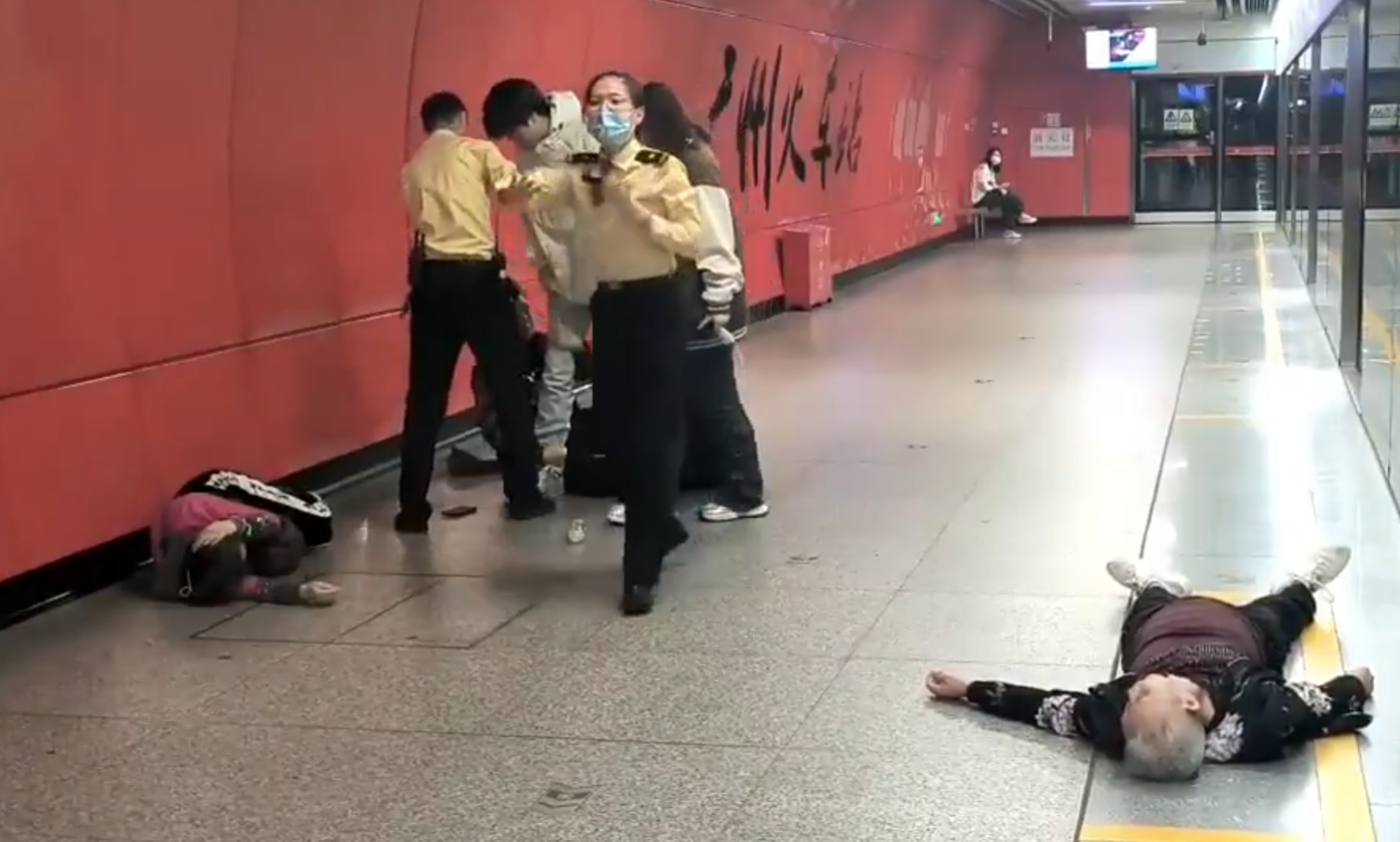 廣州地鐵站周三有一對青年男女與3名長者互毆,其中1名白髮男子倒地,地鐵工作人員上前勸阻。(影片截圖)