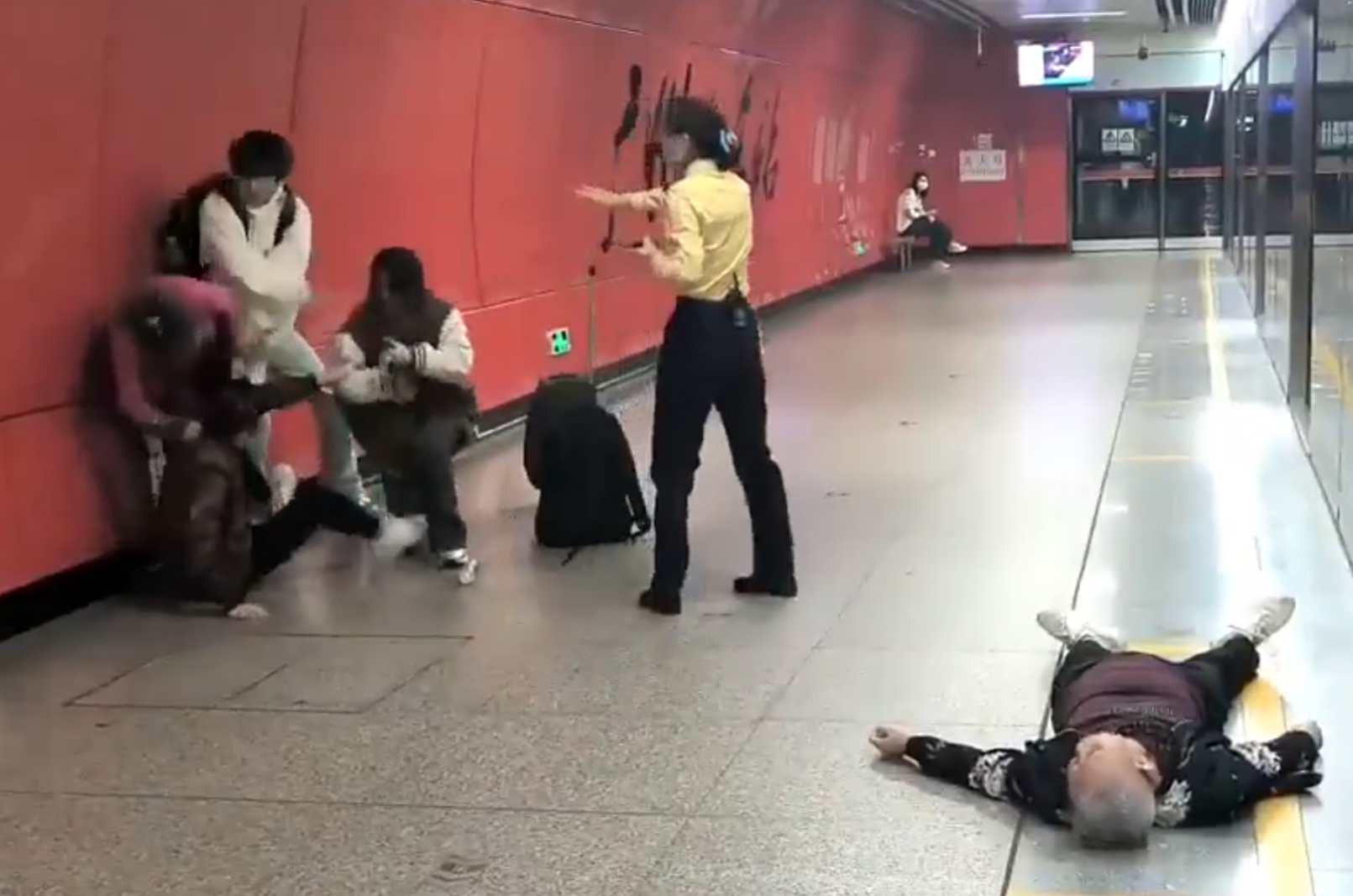 廣州地鐵站周三有一對青年男女與3名長者互毆,其中1名白髮男子倒地,地鐵工作人員上前勸阻。(影片截圖)