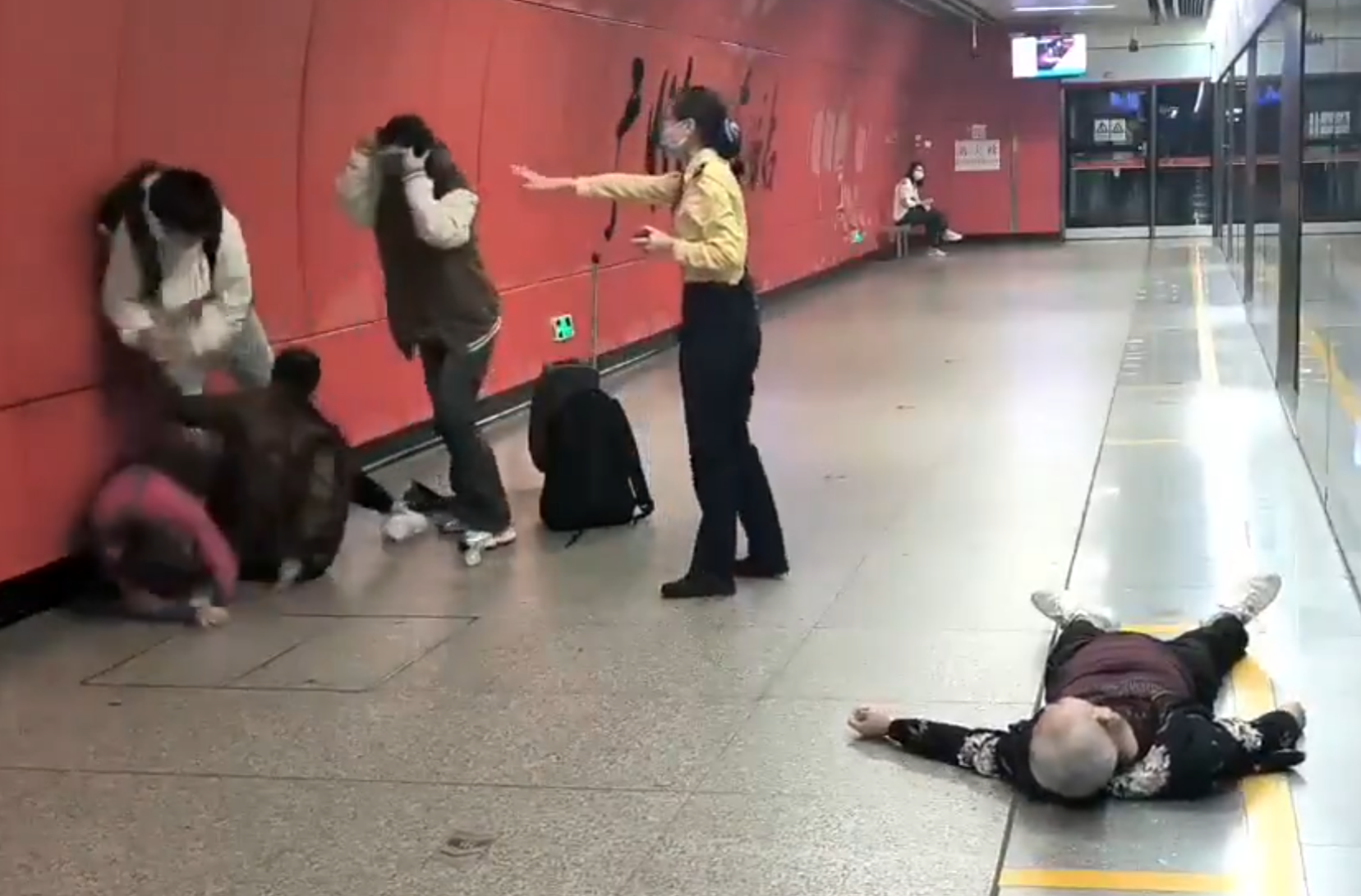 廣州地鐵站周三有一對青年男女與3名長者互毆,其中1名白髮男子倒地,地鐵工作人員上前勸阻。(影片截圖)