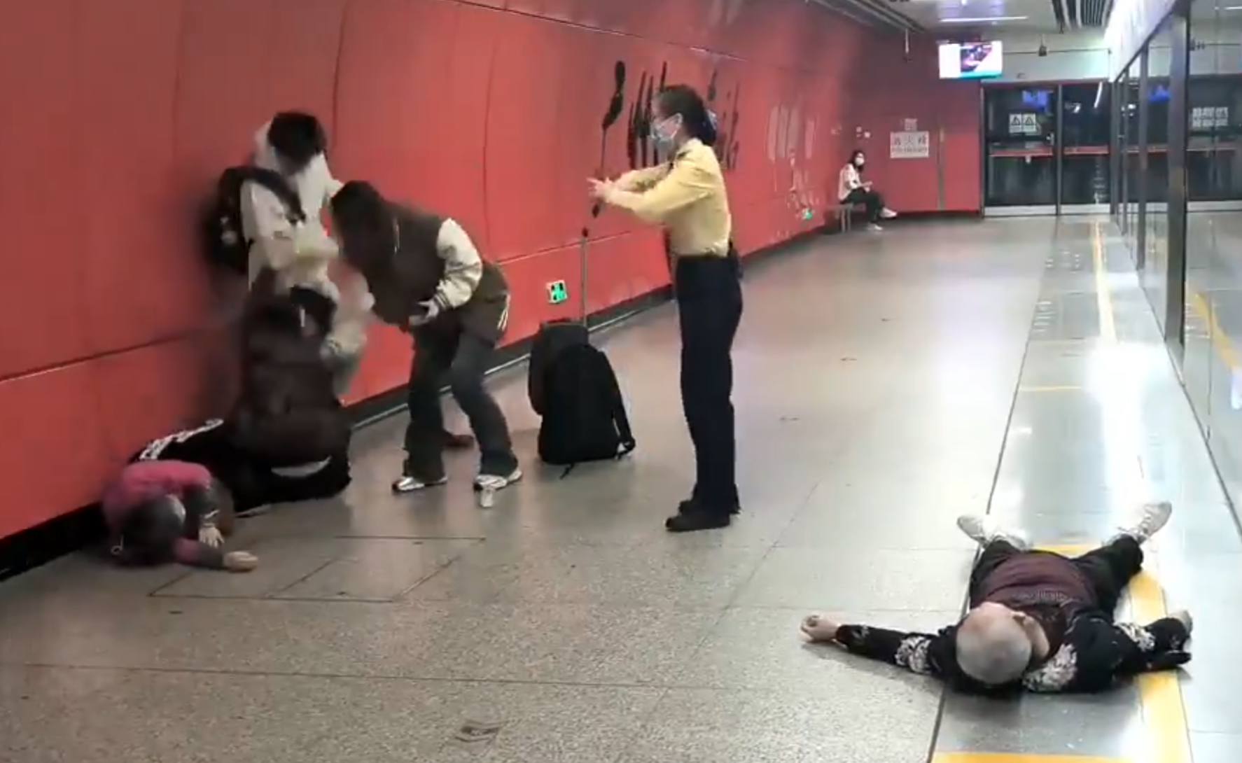 廣州地鐵站周三有一對青年男女與3名長者互毆,其中1名白髮男子倒地,地鐵工作人員上前勸阻。(影片截圖)