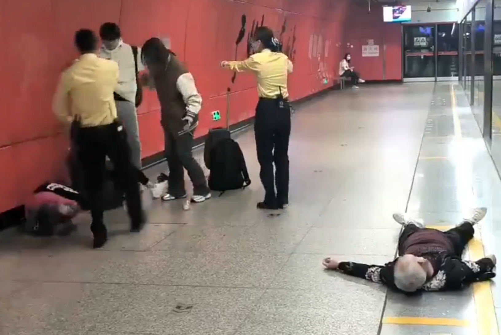 廣州地鐵站周三有一對青年男女與3名長者互毆,其中1名白髮男子倒地,地鐵工作人員上前勸阻。(影片截圖)